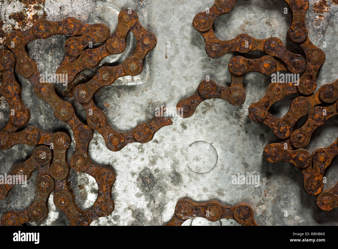 Weakest link in a strong steel rusty roller chain is broken snapped