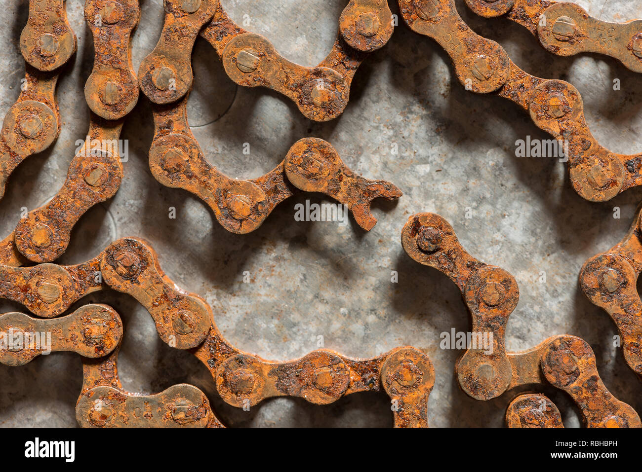 Weakest link in a strong steel rusty roller chain is broken snapped