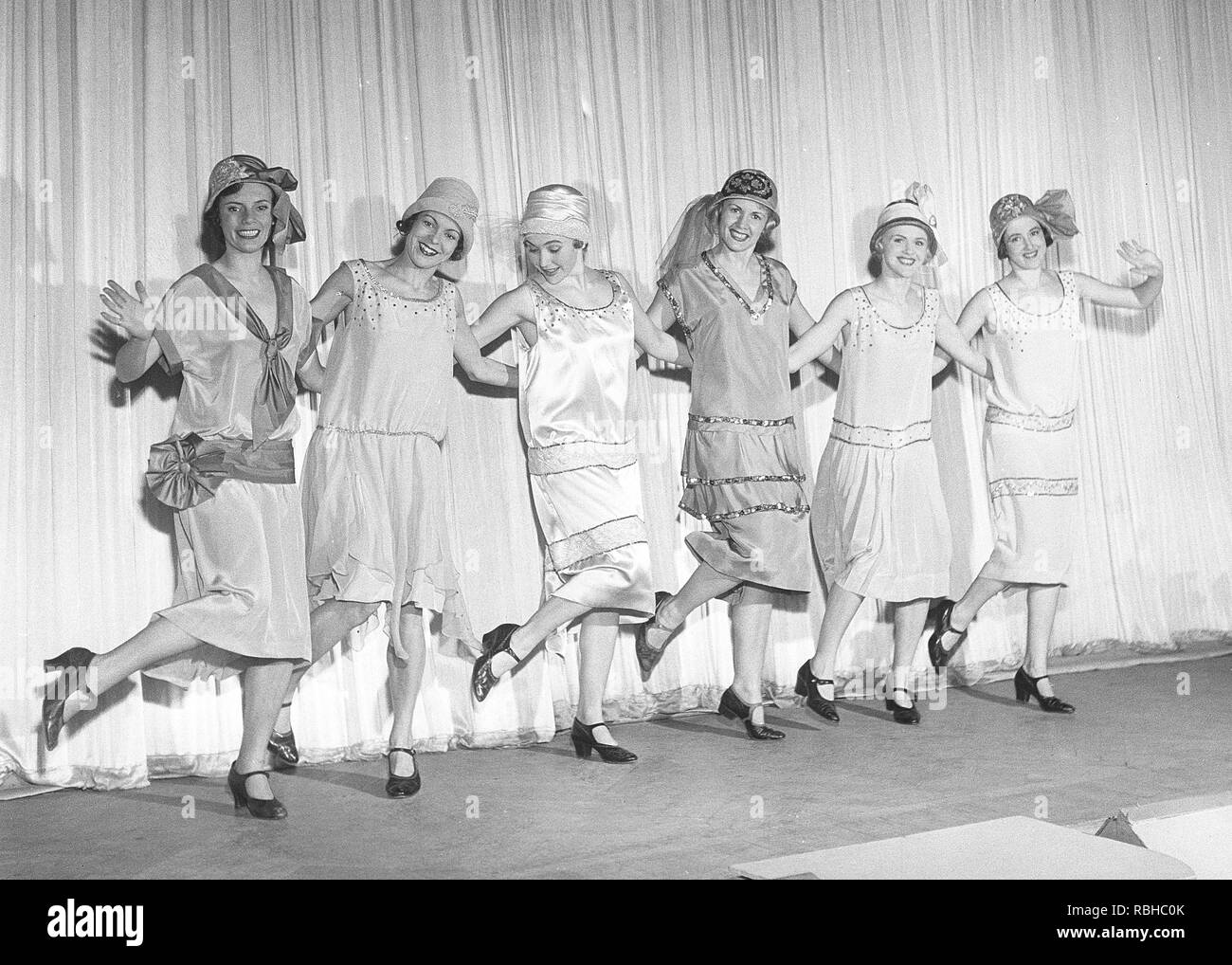 1920s remake. A group of women at a theatre are posing on stage in typical 1920s dresses and cloche hats. They are dancing the typical 1920s Charleston dance. Sweden Photo Kristoffersson Ref 1920s remake. A group of women at a theatre are posing on stage in typical 1920s dresses and cloche hats. They are dancing the typical 1920s Charleston dance. Sweden Photo Kristoffersson Ref