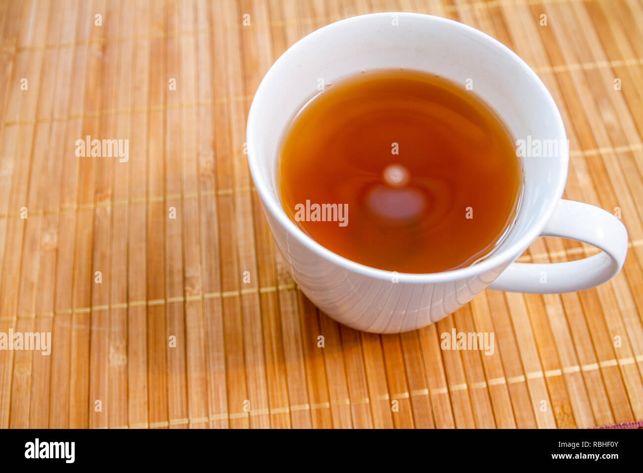 Hot white mug of healthy green tea with honey on a bamboo wood background Stock Photo