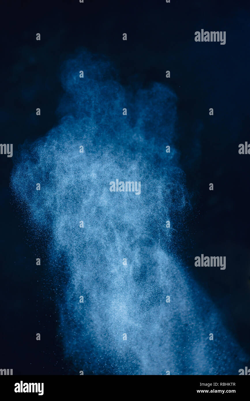 Flour powder explosion in motion. Wheat dust on a black background. Action food photography