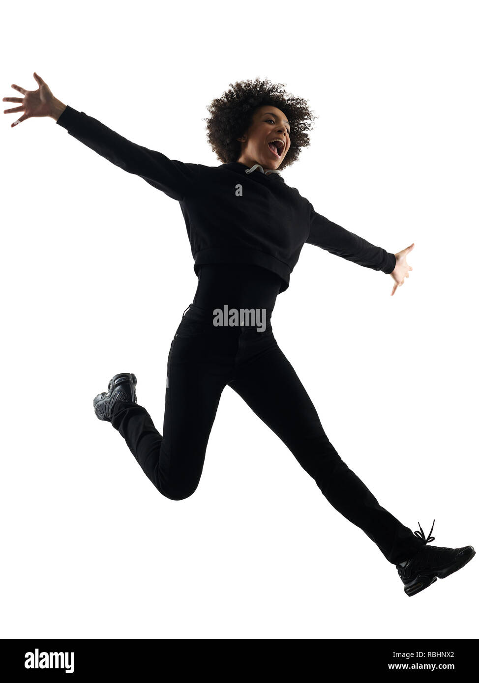 one mixed race african young teenager girl woman jumping happy in studio shadow silhouette isolated on white background Stock Photo