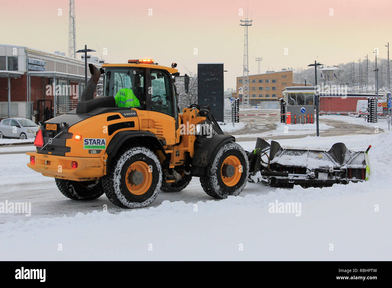 Helsinki, Finland  - January 9, 2019: Snow removal with Volvo L50G compact wheel loader equipped with snowplow in Helsinki on a day of winter. Stock Photo