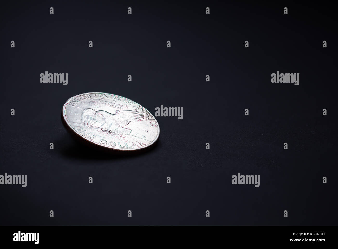 One dollar coin on a dark grey background Stock Photo