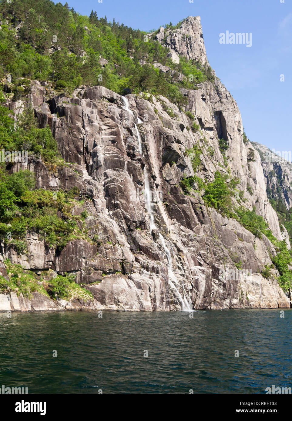 A one day fjord cruise in Lysefjorden east of Stavanger Norway, unspoiled nature with steep mountainsides, a cascade into the fjord Stock Photo