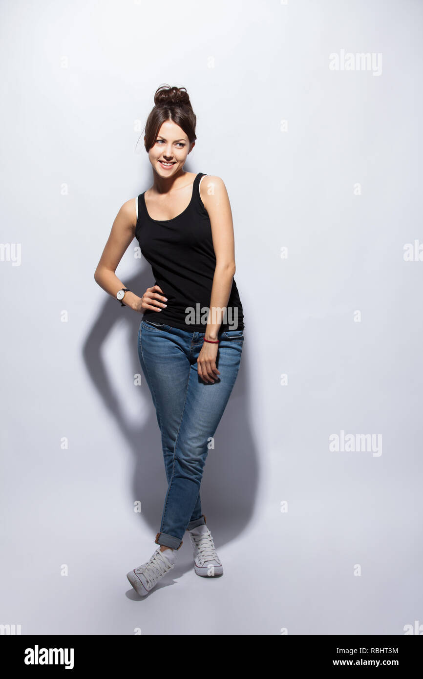 Full length portrait of a smiling casual woman standing on white ...