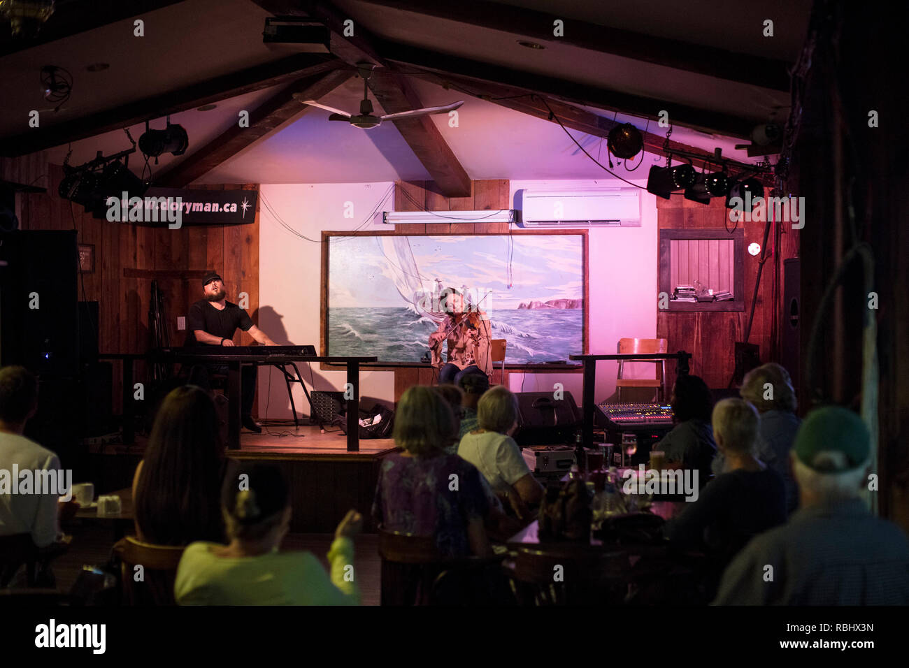 CHETICAMP, CAPE BRETON, NOVA SCOTIA, CANADA - July 17, 2018: Chrissy Crowley (C), and Jason Roach (L), perform traditional Cape Breton fiddle music. Stock Photo