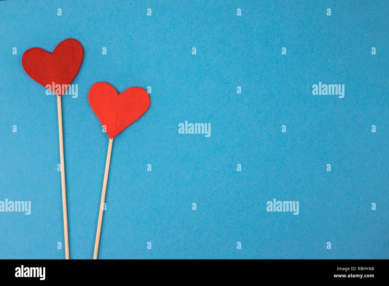 Two felt hearts on a blue background. Stock Photo