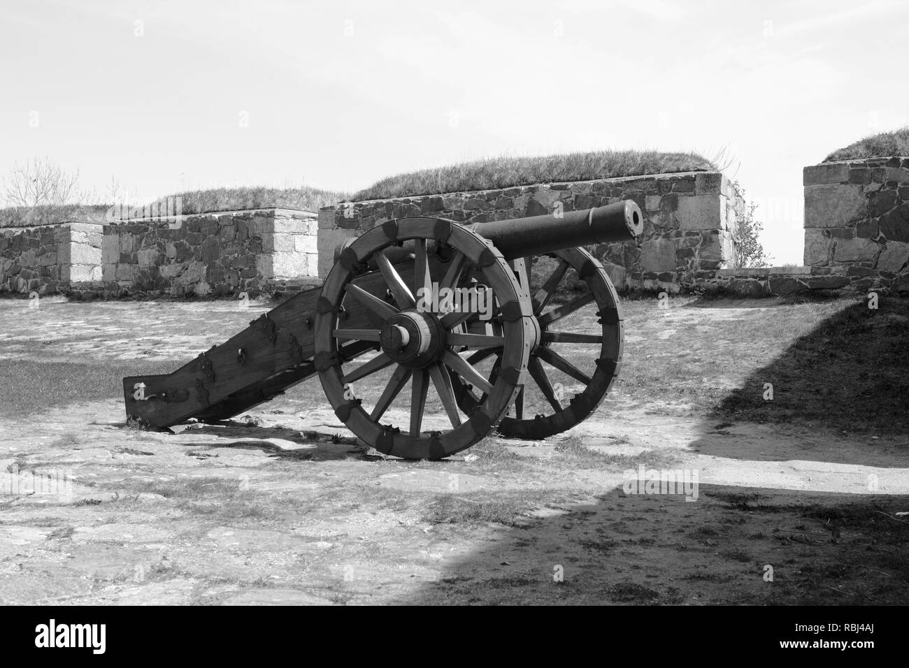 Old military cannon mounted on wheels, displayed in a bastion on sea fortress Suomenlinna, Helsinki - monochrome processing Stock Photo