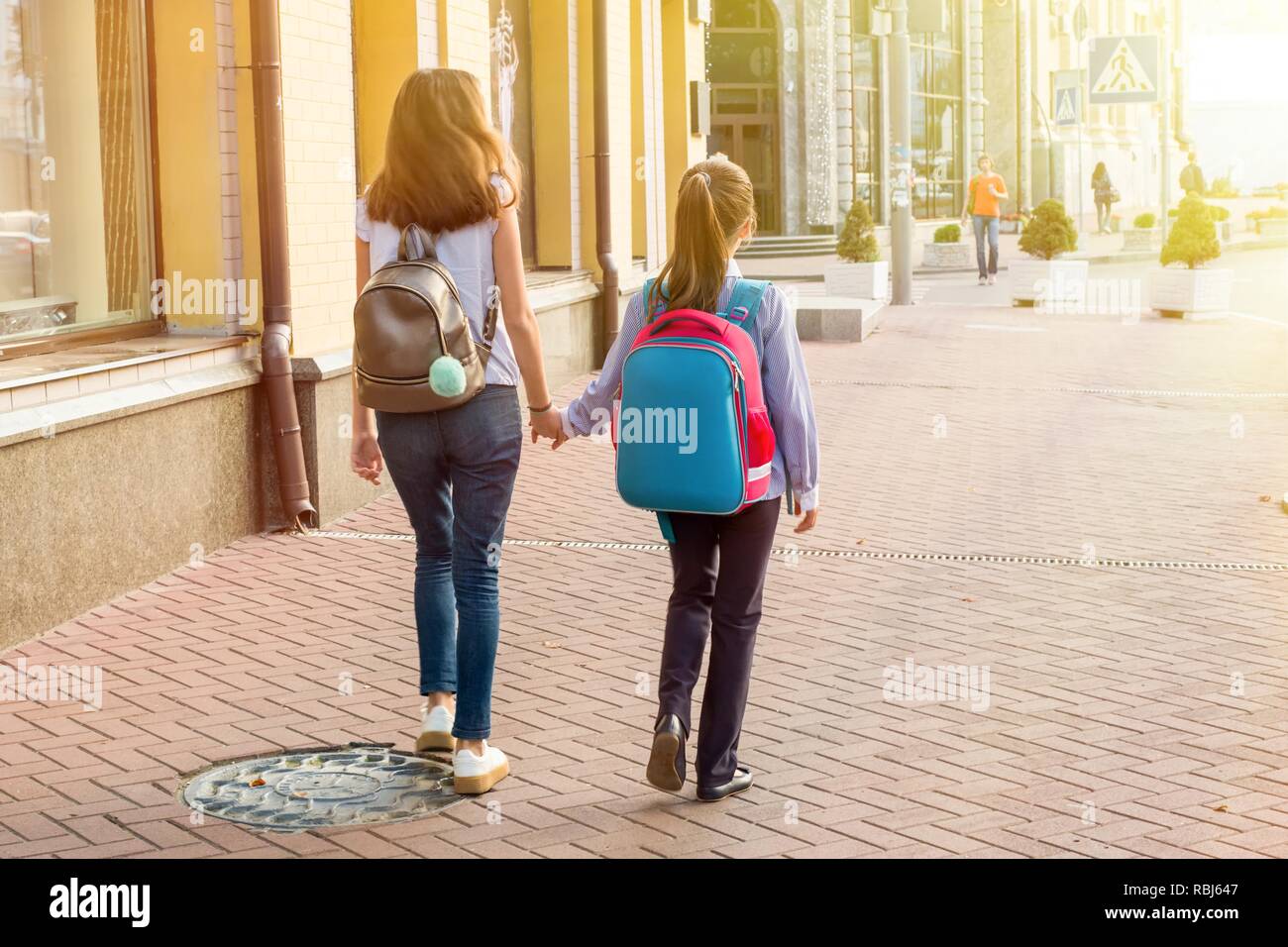 Back view, girls students go to school holding hands Stock Photo - Alamy