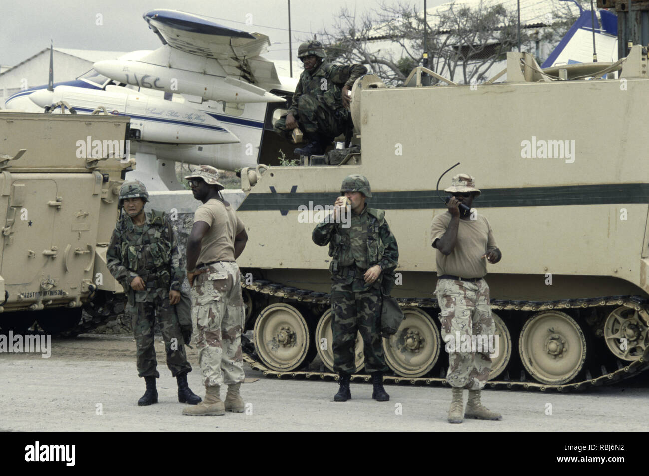 10th October 1993 U.S. Army soldiers stand next to their M577A1 Bradley command post armoured vehicles. They have just arrived at Mogadishu Airport in Somalia. Stock Photo