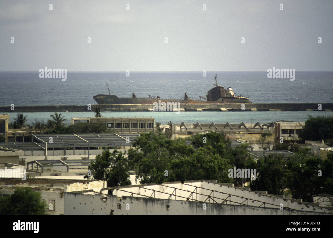 11th October 1993 The wreck of the Felix lies against the harbour wall of the Old Port in Mogadishu, Somalia. Stock Photo