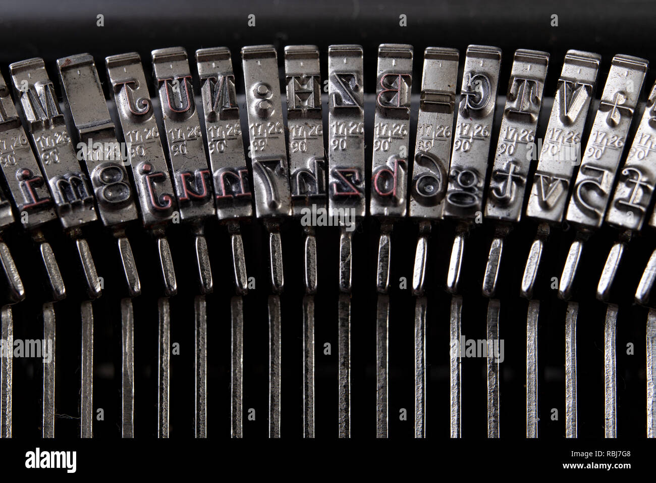 Font in a typewriter. Metal stamps for imprinting letters on a white