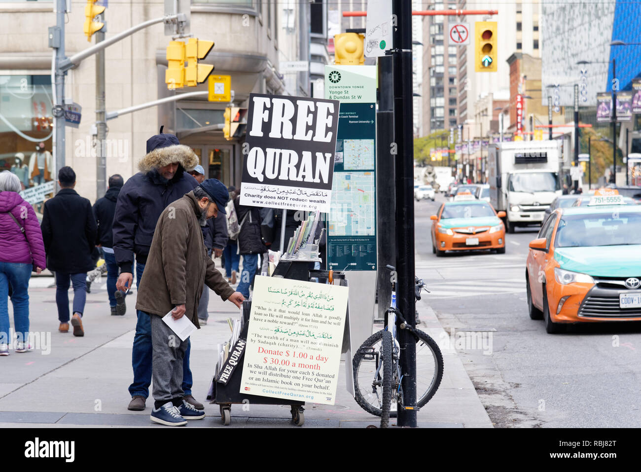 A muslim man at a street stand giving away free copies of the Koran, Toronto, Canada Stock Photo