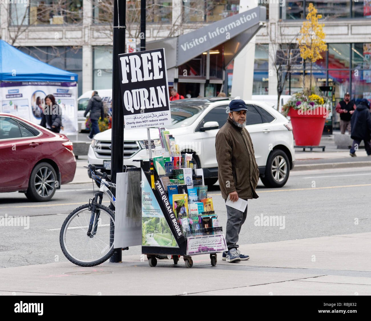 A muslim man at a street stand giving away free copies of the Koran, Toronto, Canada Stock Photo