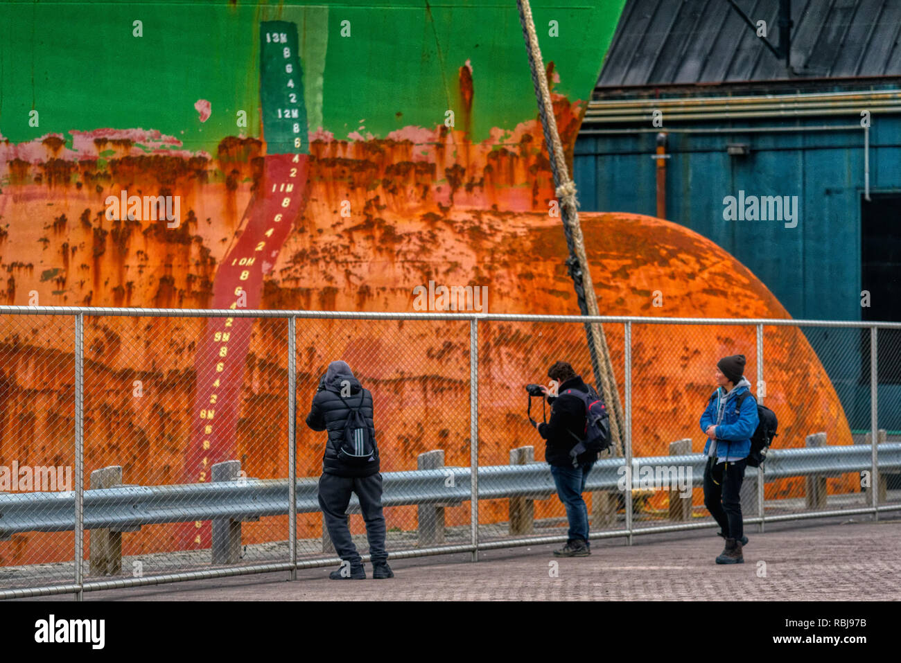 Two photographers taking pictures of the bulk carrier ship Wigeon in Toronto Harbour, Canada Stock Photo