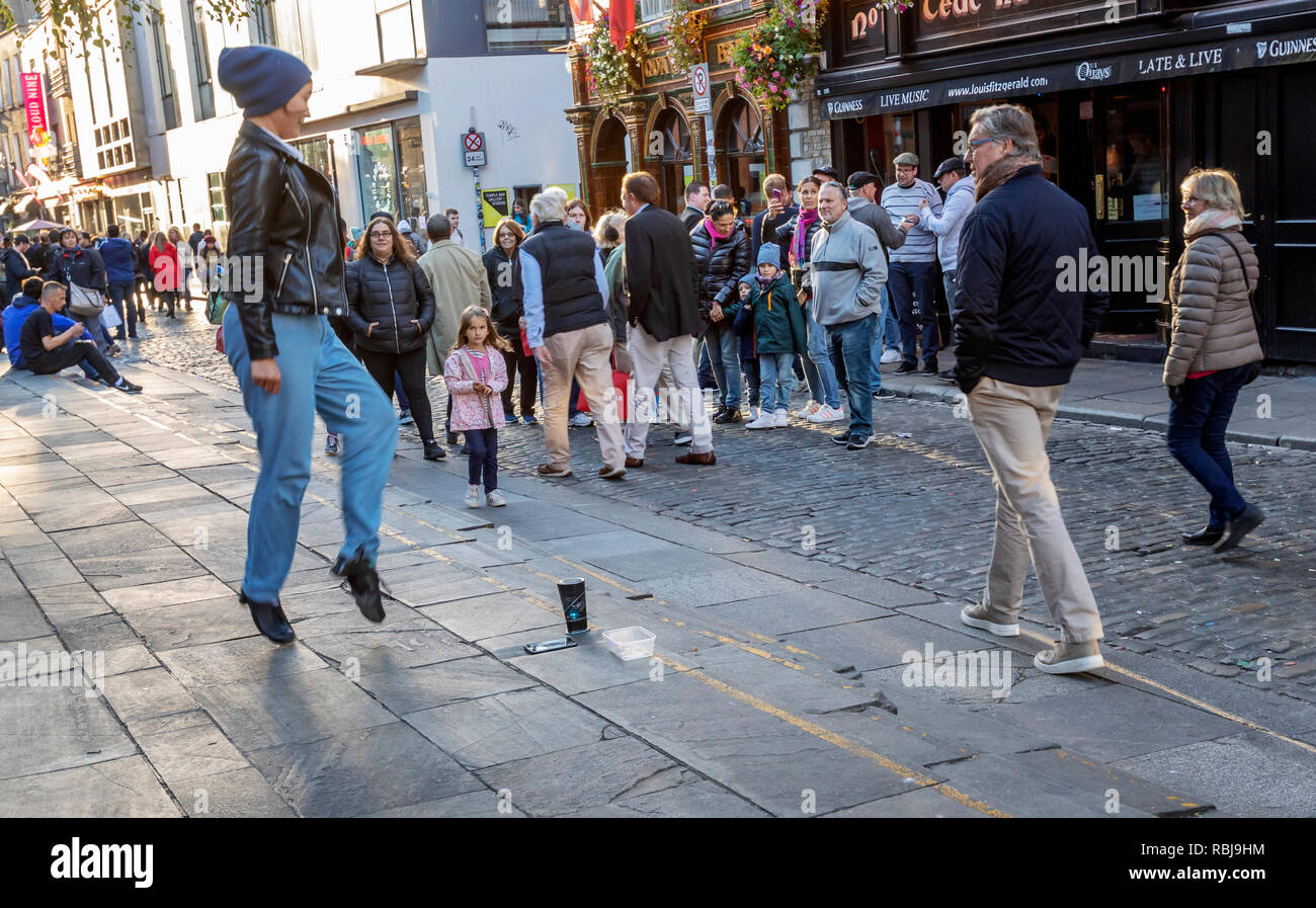 A young woman entertains tourists doing an Irish Step Dance in the Temple Bar district in Dublin, Ireland. Stock Photo