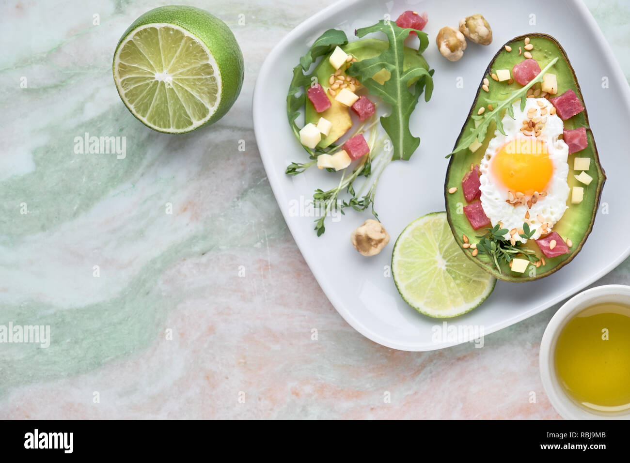 Keto diet dish baked Avocado boat with ham cubes, quail egg and cheese