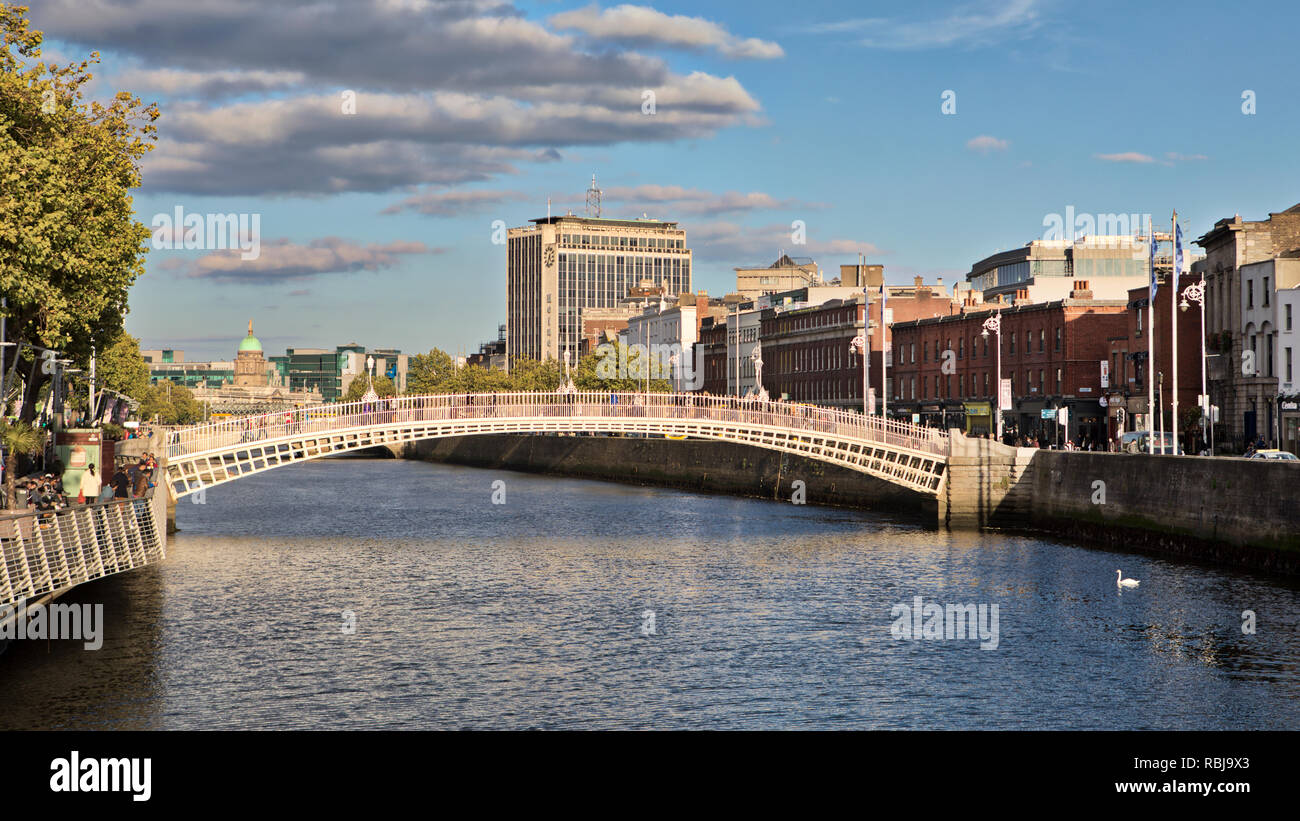 People walk over the Ha'penny Bridge over the Liffey River in Dublin, Ireland. Stock Photo