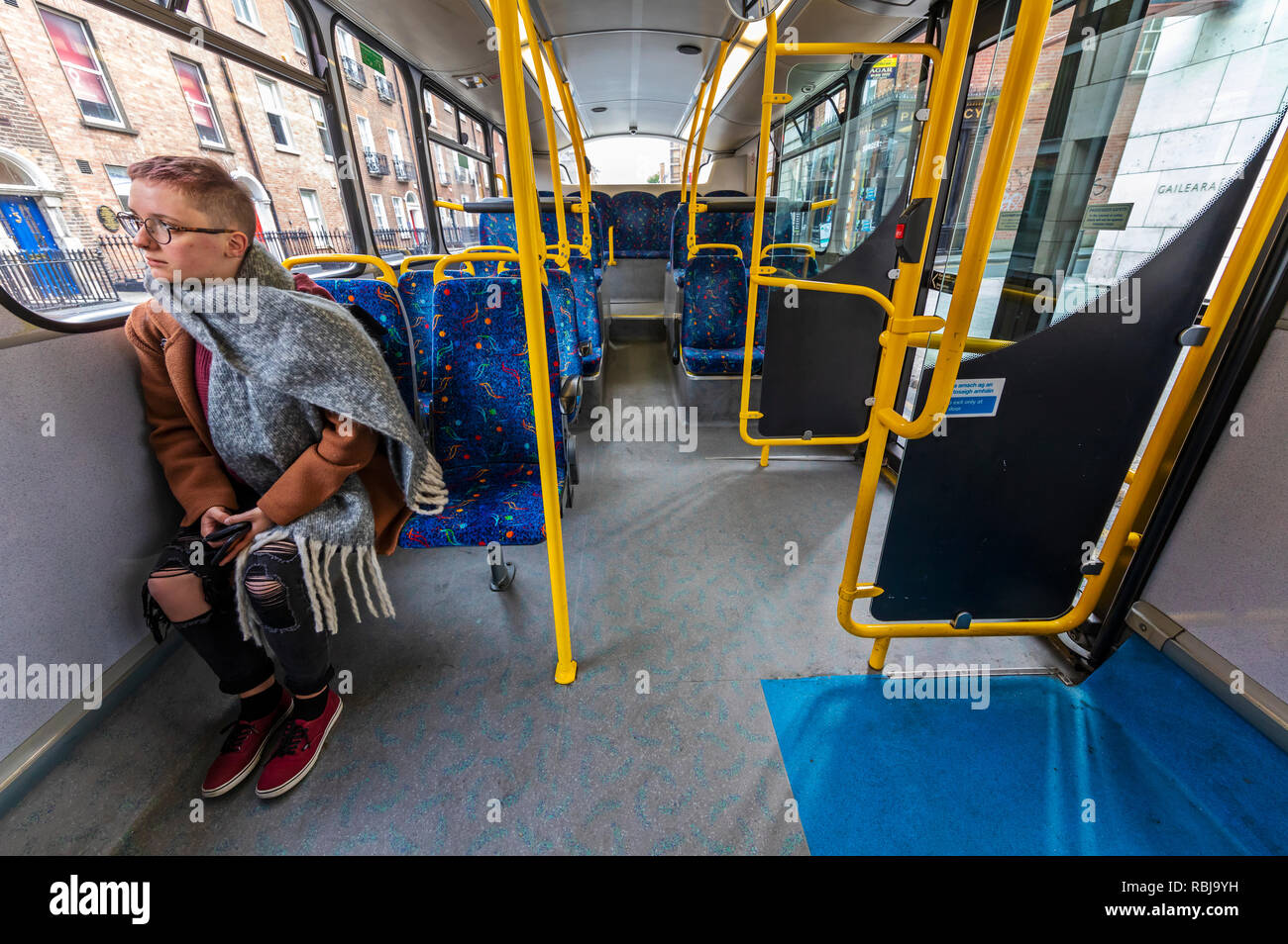 A young woman riding a bus in Dublin, Ireland. Stock Photo