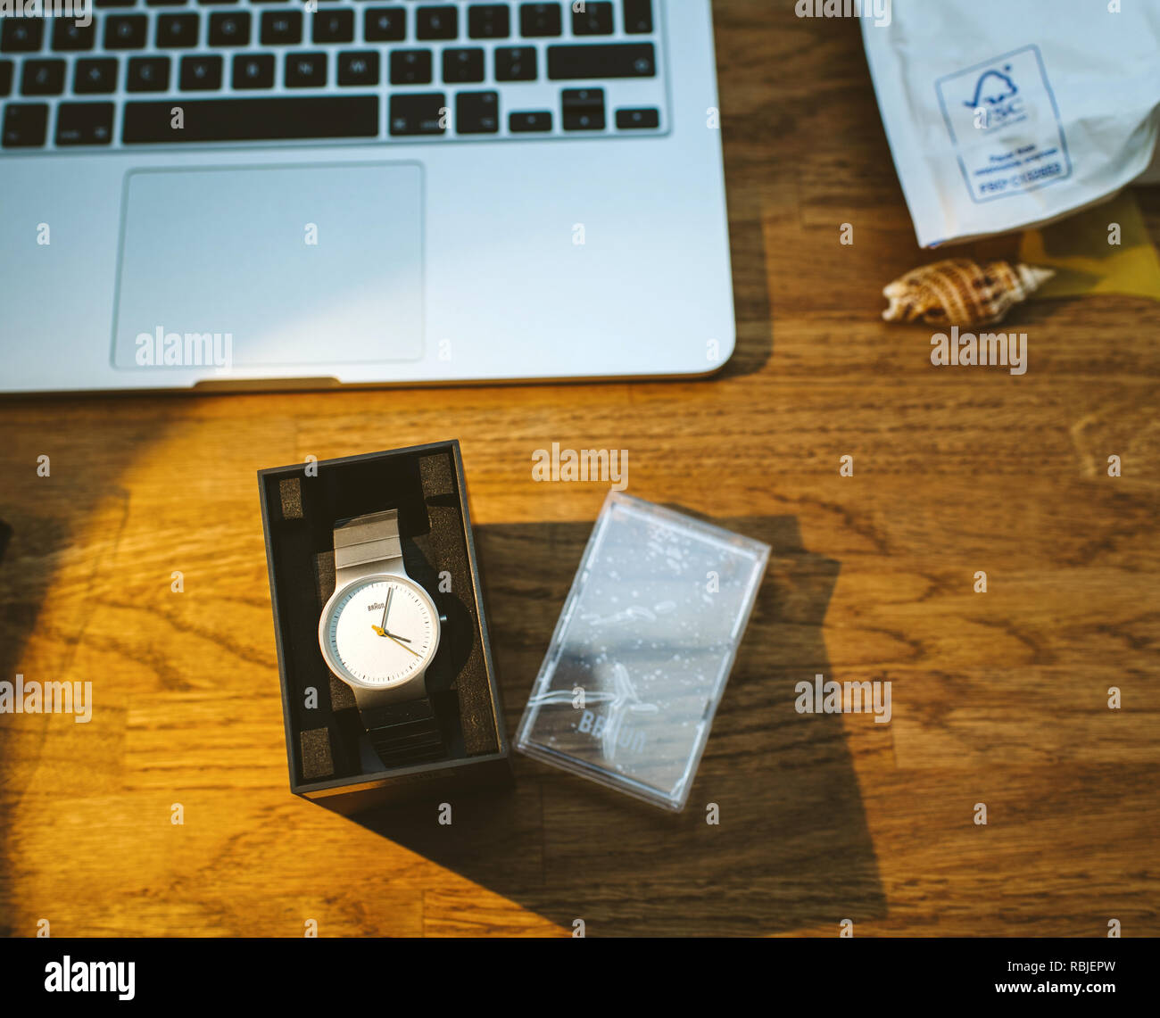 PARIS, FRANCE - DEC 5, 2017: unboxing new Braun German watch clock on work table with Apple MacBook retina laptop working Stock Photo