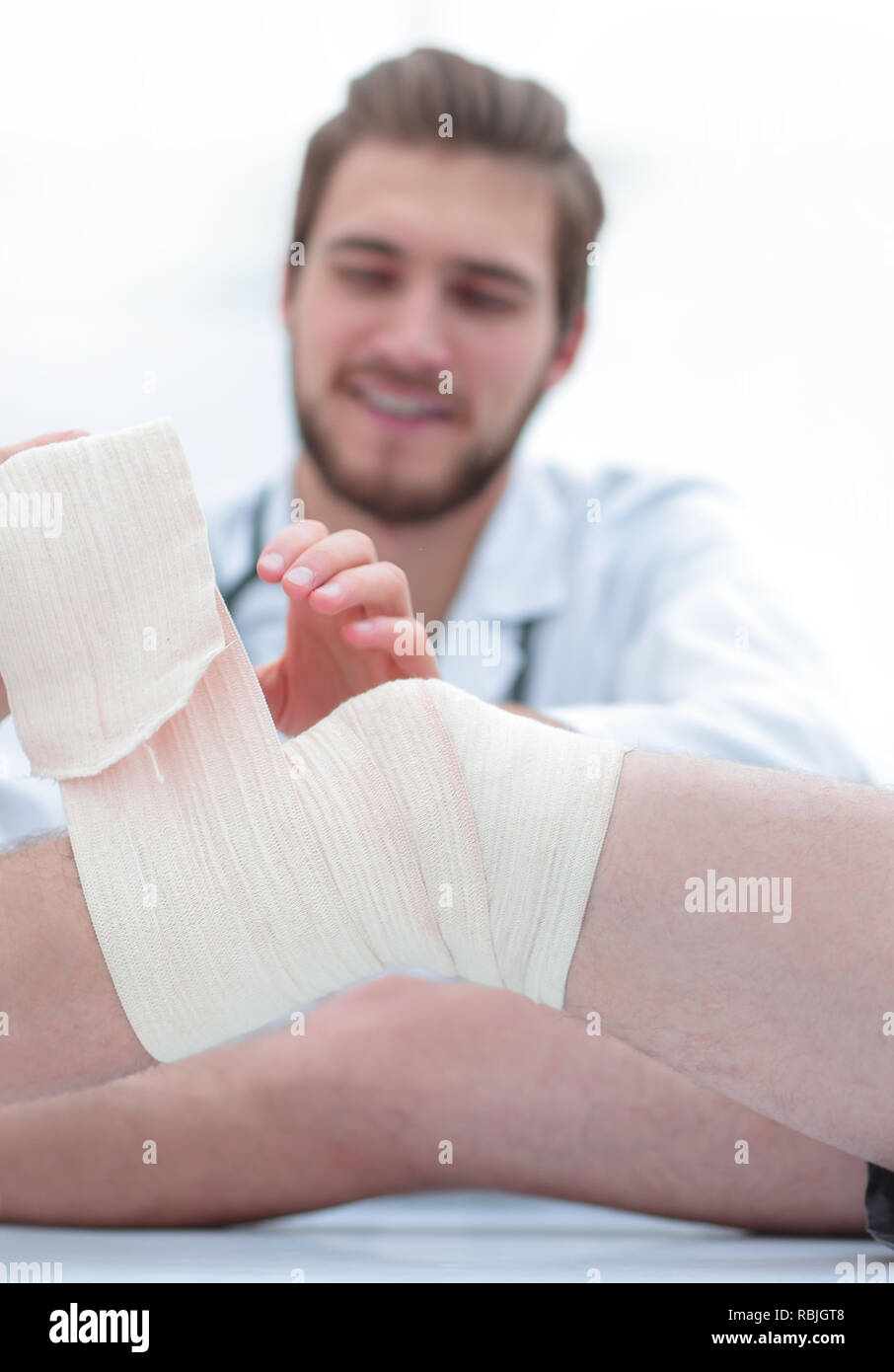 doctor bandaging a wound on the leg of the patient Stock Photo Alamy