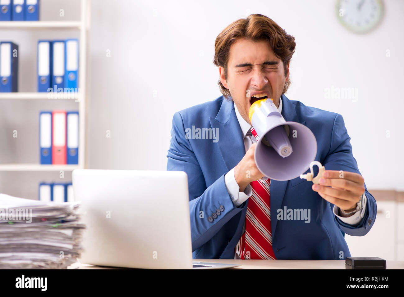 Deaf employee using hearing aid in office Stock Photo Alamy