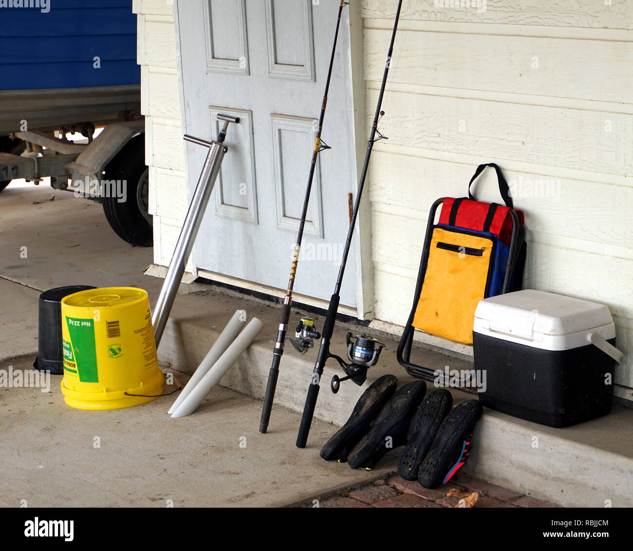 fishing gear ready to go. fishing rods, chair, yabby pump, bucket, cooler,  rod holders, aqua shoes Stock Photo - Alamy