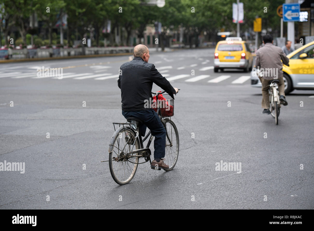 People riding bikes on the streets of Shanghai in China Stock Photo