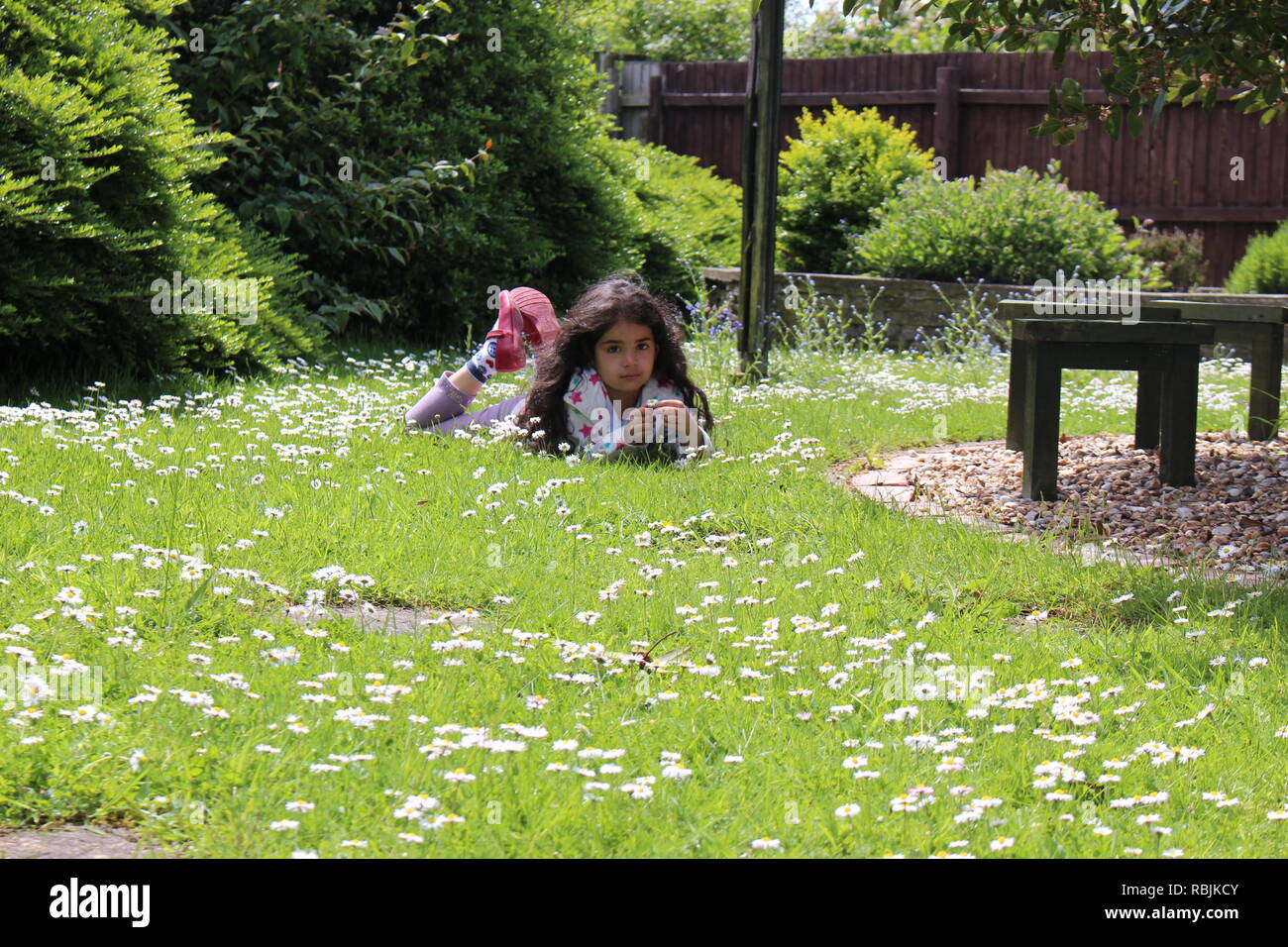 girl lieing in garden with daisys Stock Photo