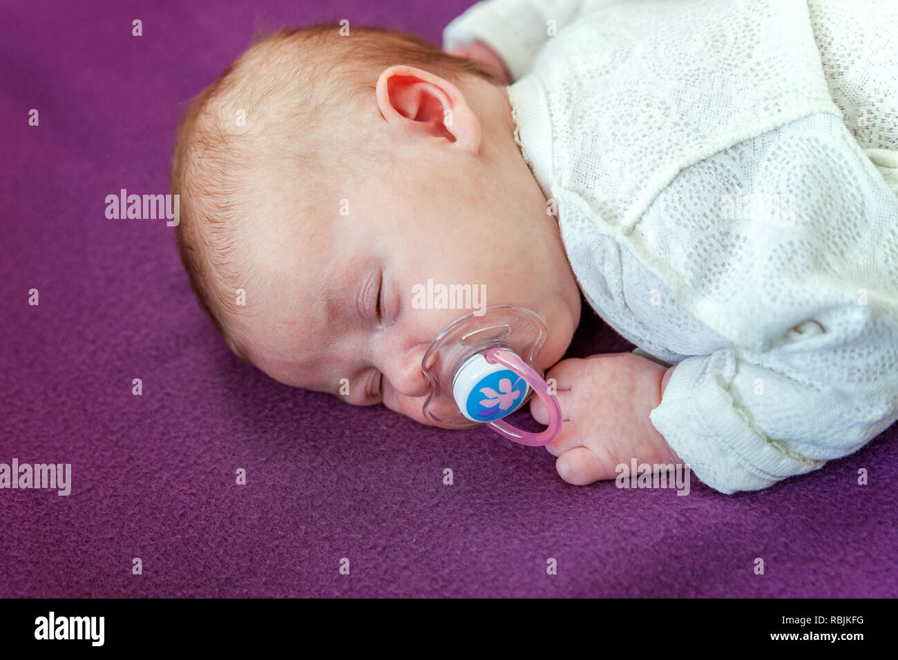 Soft Portrait Of Peaceful Sweet Newborn Infant Baby Lying On Bed