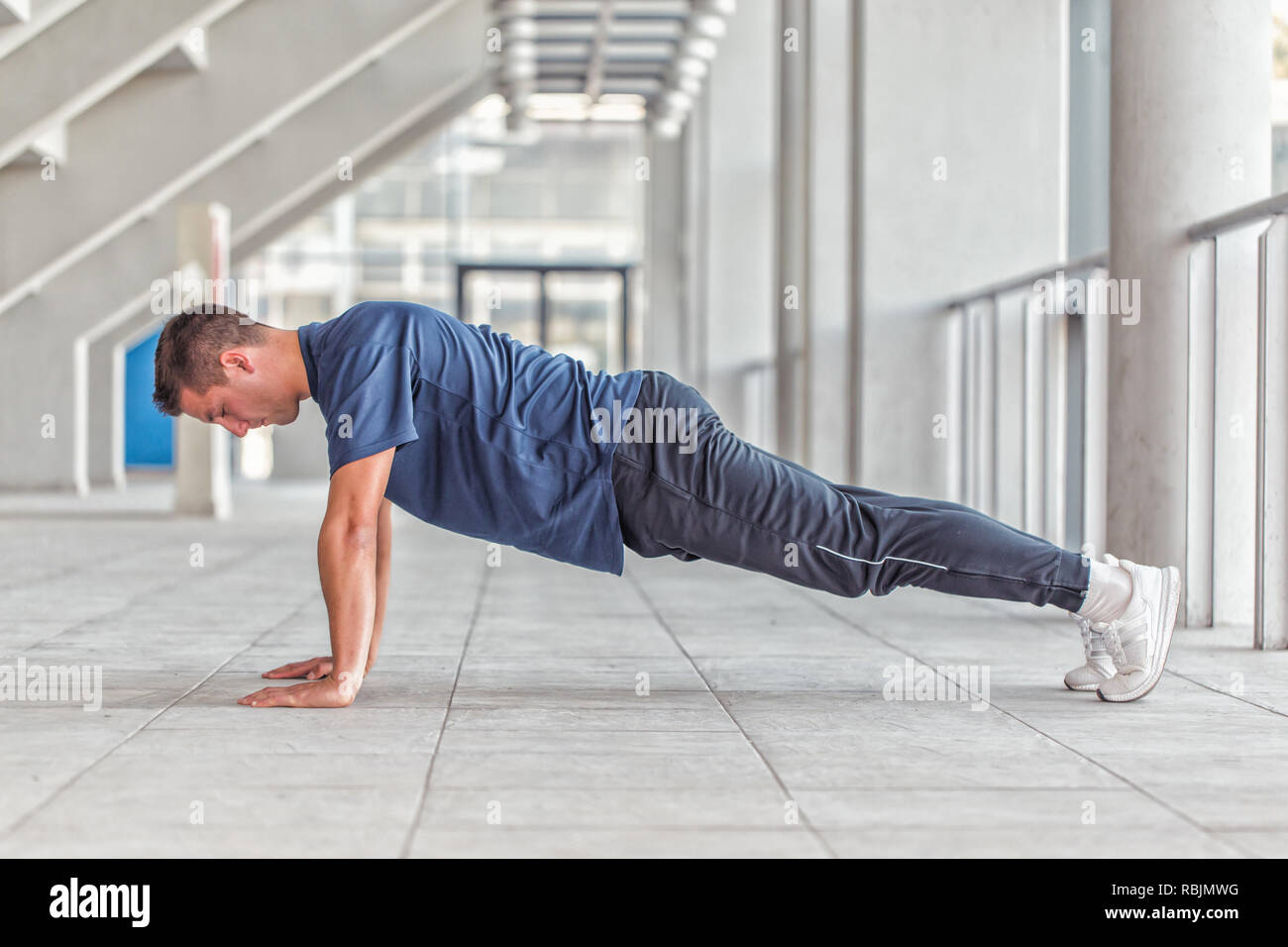 Picture of a young athletic man doing push ups in a sports center ...