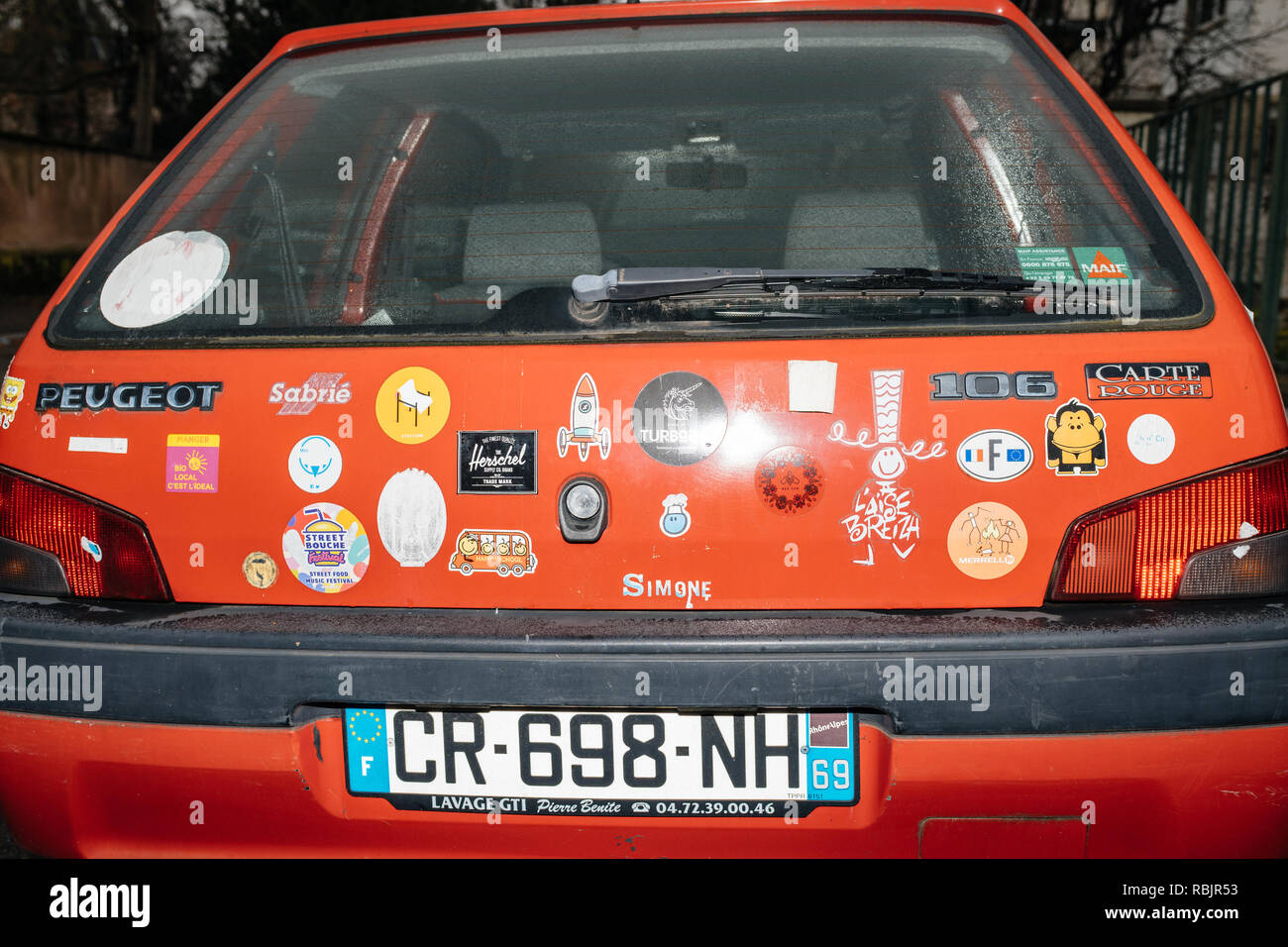 Strasbourg, France - Jan 1, 2019: Rear view of red vintage Peugeot car with multiple stickers from know cartoon to diverse brands  Stock Photo