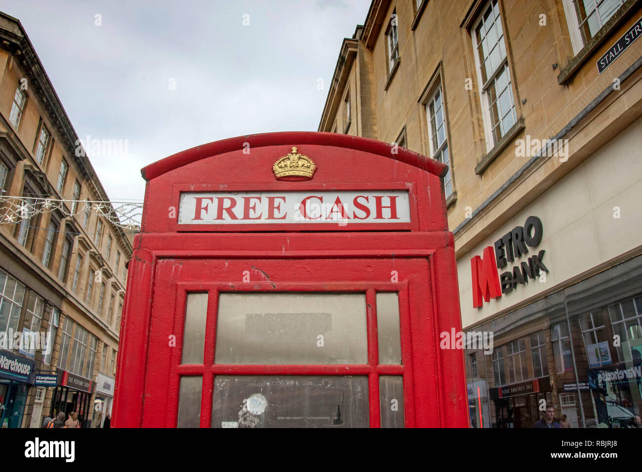 Old red telephone box now used as a cash machine in Bath, England, UK Stock Photo