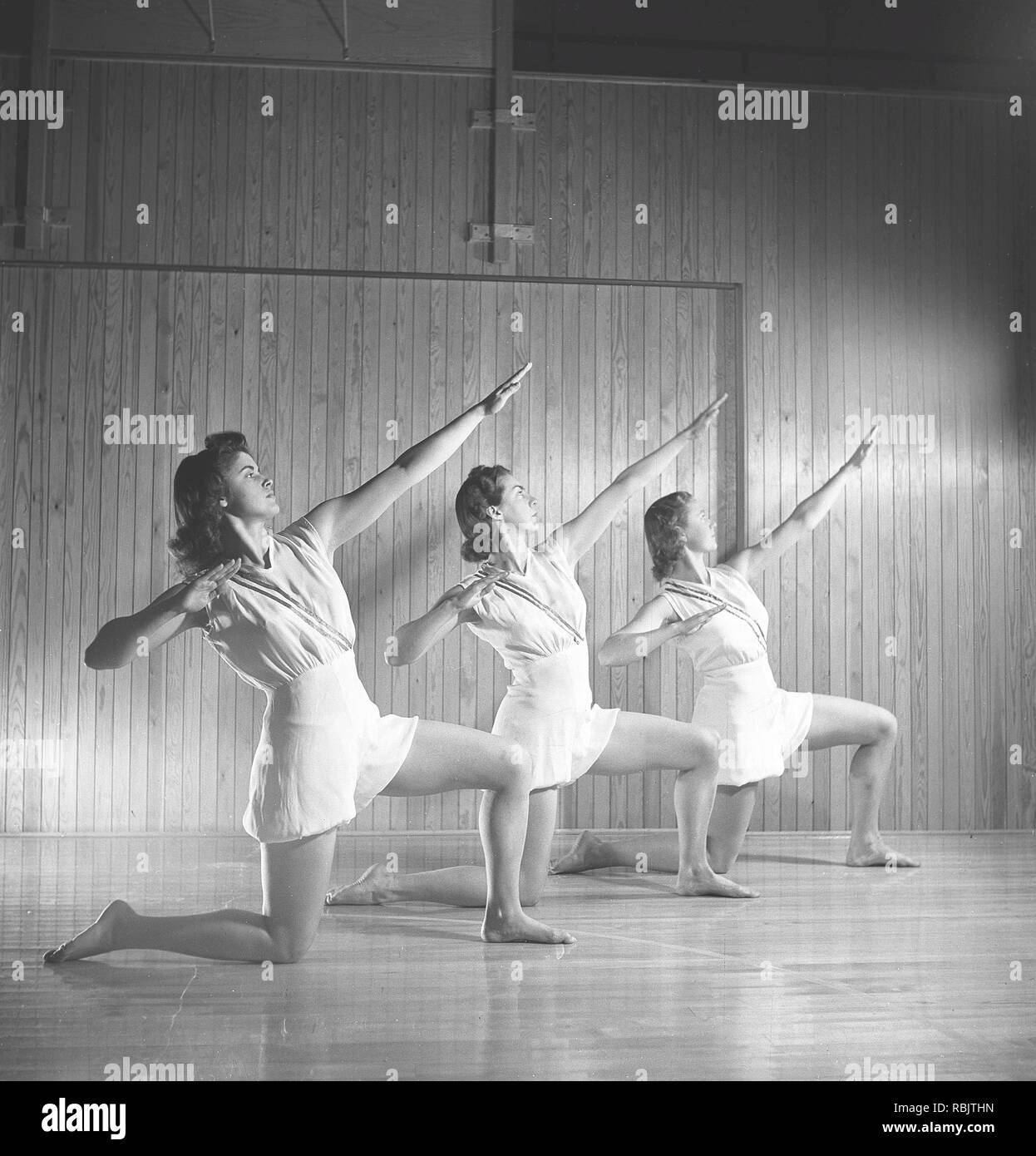 Gymnastics in the 1940s. Three young female gymnasts are practicing together and doing the same movement. 1940s Sweden Photo Kristoffersson ref M107-1 Stock Photo