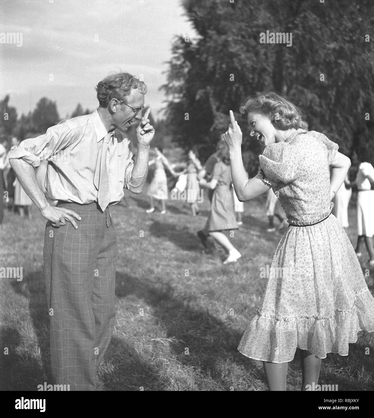 Summer dance in the 1940s. At an outdoor summer dance event a man and a woman are standing doing some odd dancing. Photo Kristoffersson Ref 219-29. Sweden 1941 Stock Photo