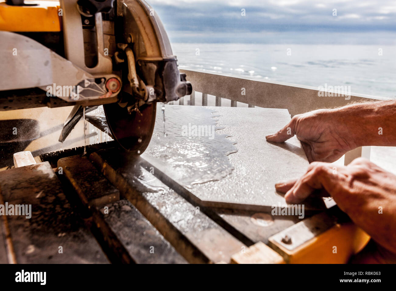 Man Cutting Tile With Wet Saw Stock Photo