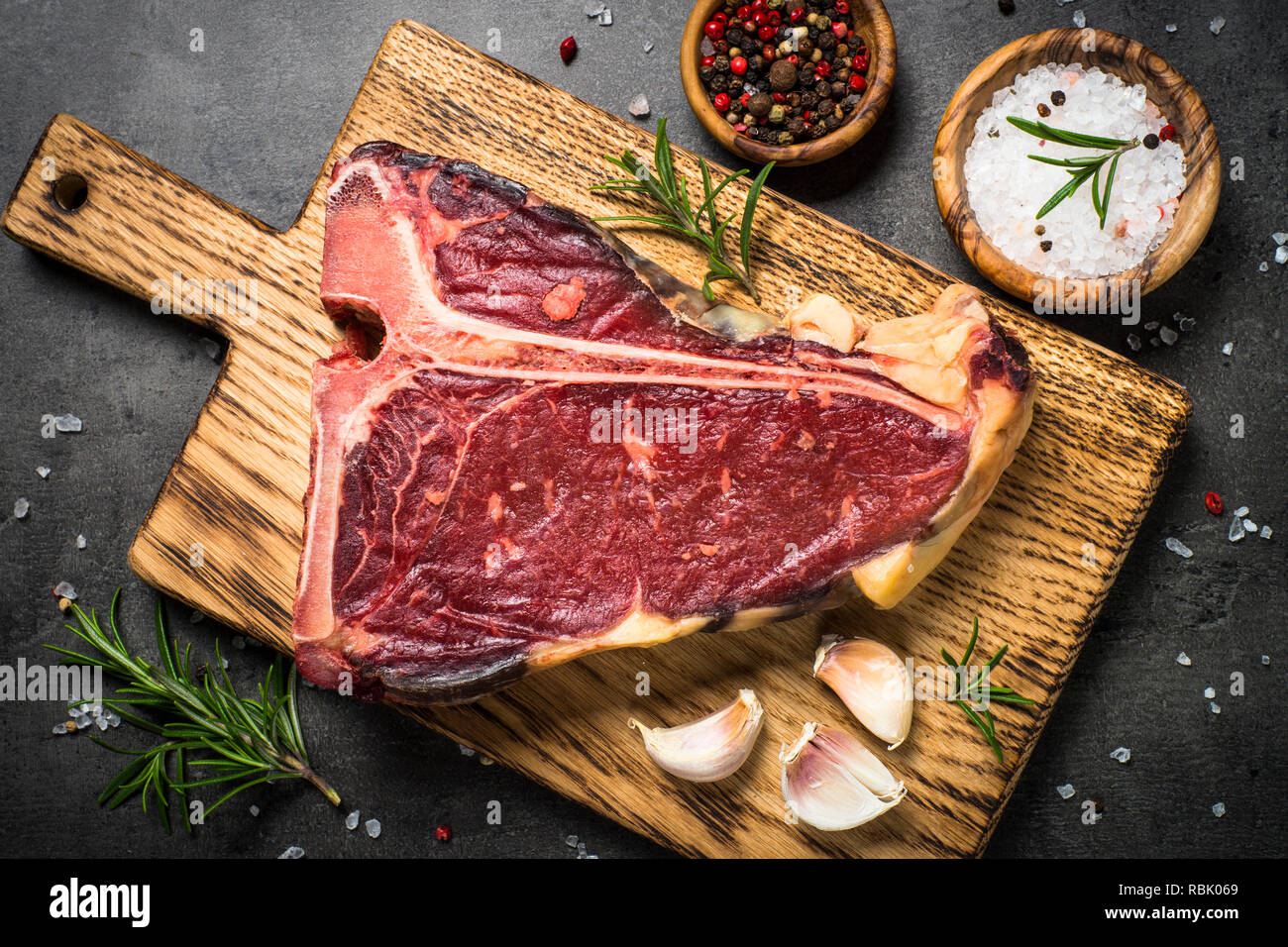 T-bone beef steak on black with spices.  Stock Photo