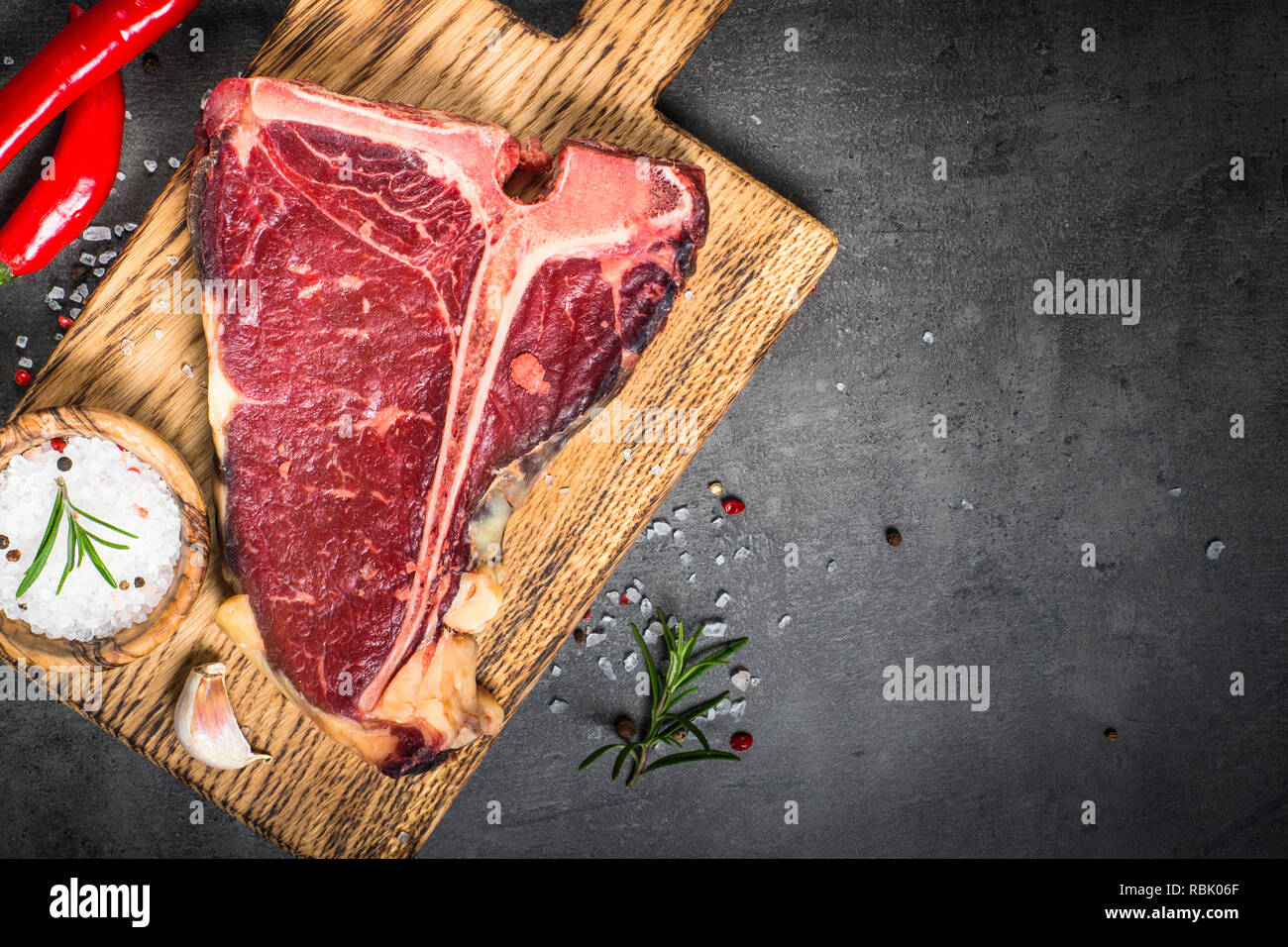 T-bone beef steak on black with spices.  Stock Photo