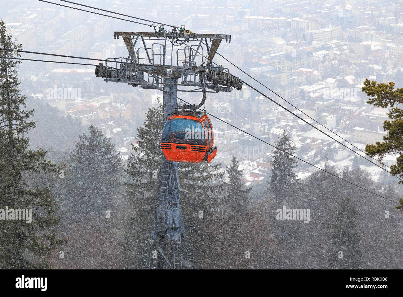Cableway with cable car on winter day with Piatra Neamt city on valley Stock Photo