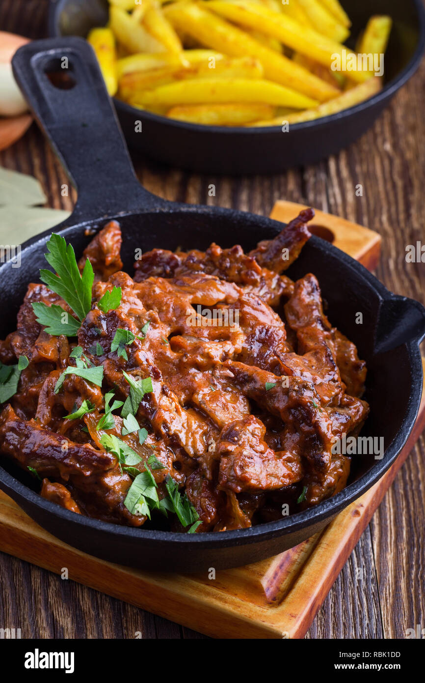 Beef Stroganoff with tomato sauce and sour cream and fried potato