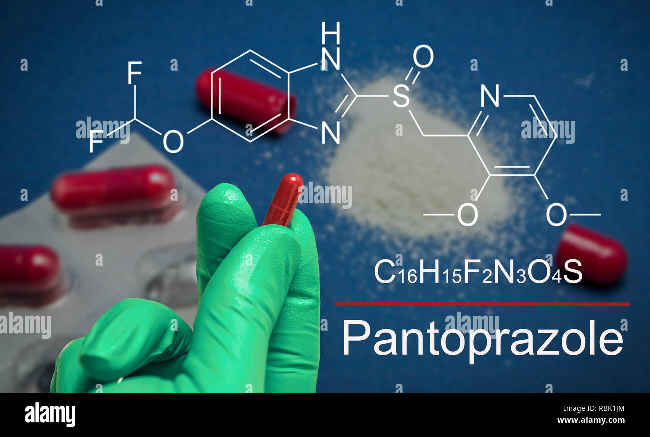 Hand with green latex glove holds a capsule of pantoprazole, chemical composition, conceptual image Stock Photo