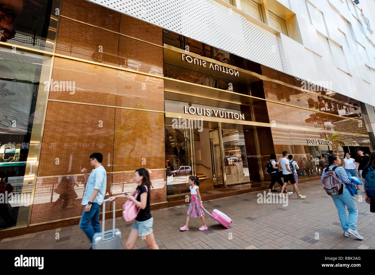 Tourists are seen passing in front of  LV  (Louis Vuitton) store in Hong Kong. Stock Photo