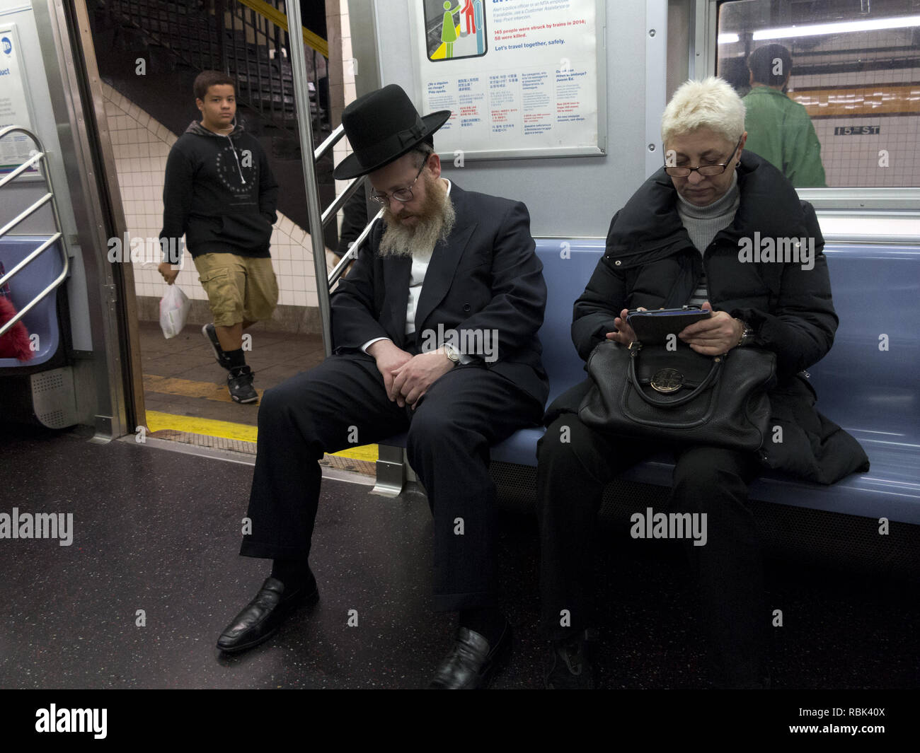 NYC subway commuters on the F train in Brooklyn, NY. Stock Photo