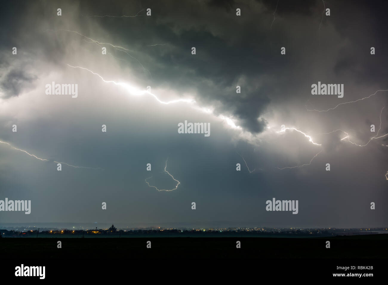 Lightnings over city during thunderstorm Stock Photo