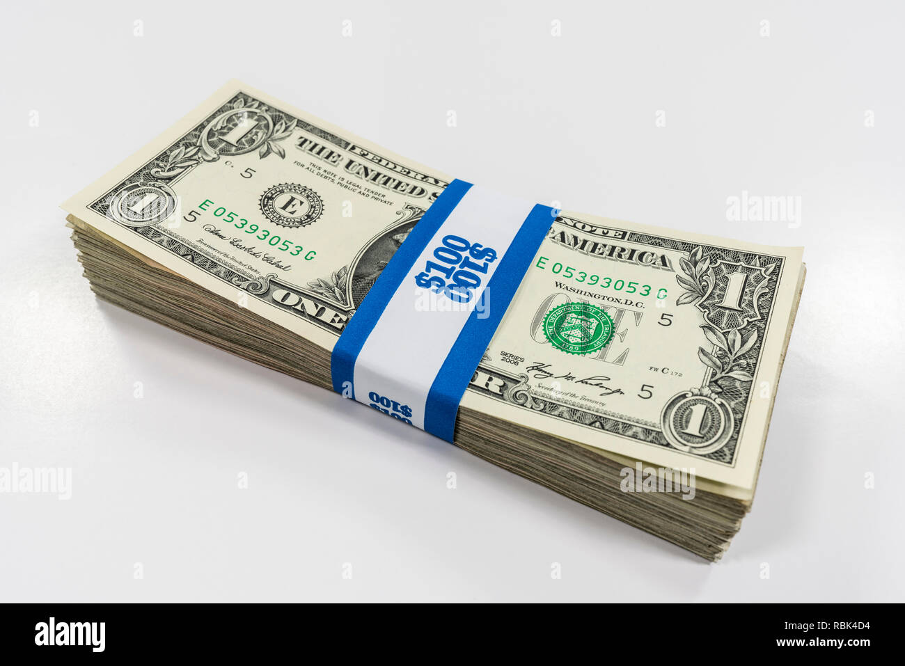 Pack of one dollar bills wrapped with $100 paper currency strap. Stock Photo