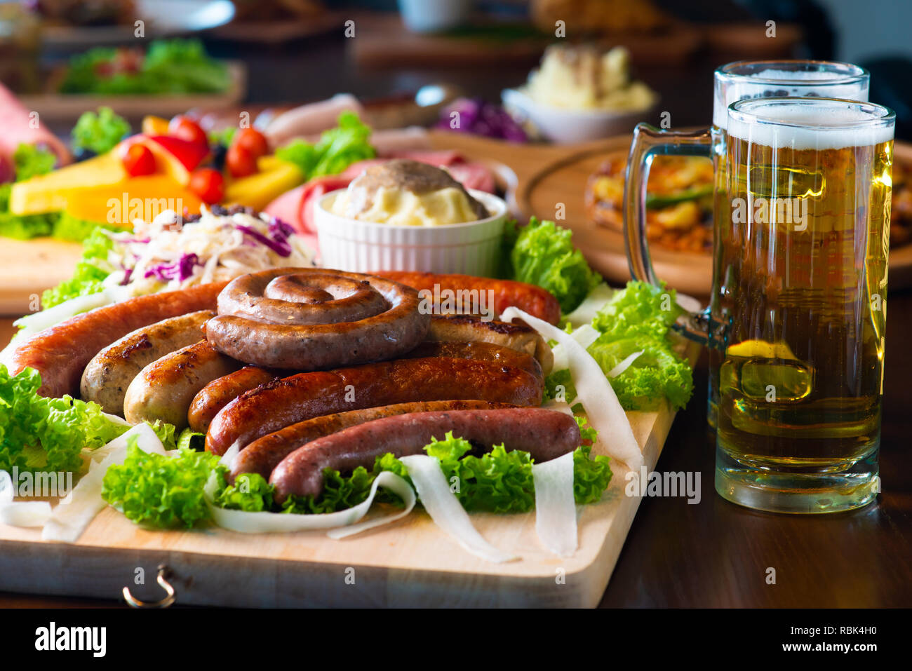 Bavarian veal sausage breakfast with sausages, soft pretzel and mild mustard on wooden board Stock Photo