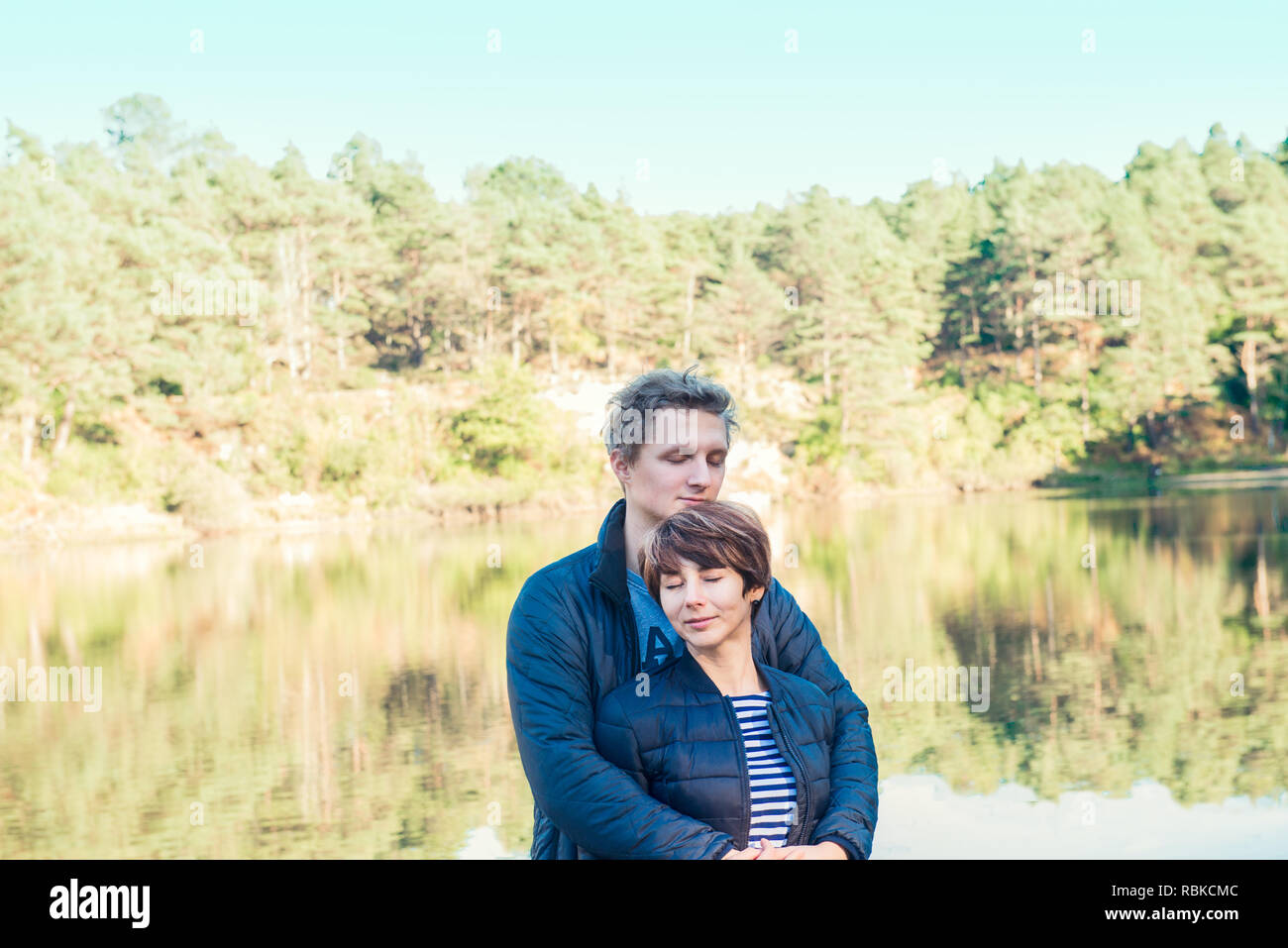 Two attractive dreamy people, couple in casual outfit at wild forest near water. Idyllic calm peaceful life style person freedom concept. Selective fo Stock Photo