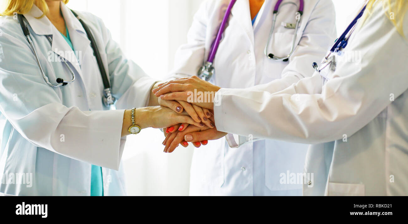 Doctors and nurses in a medical team stacking hands. Stock Photo