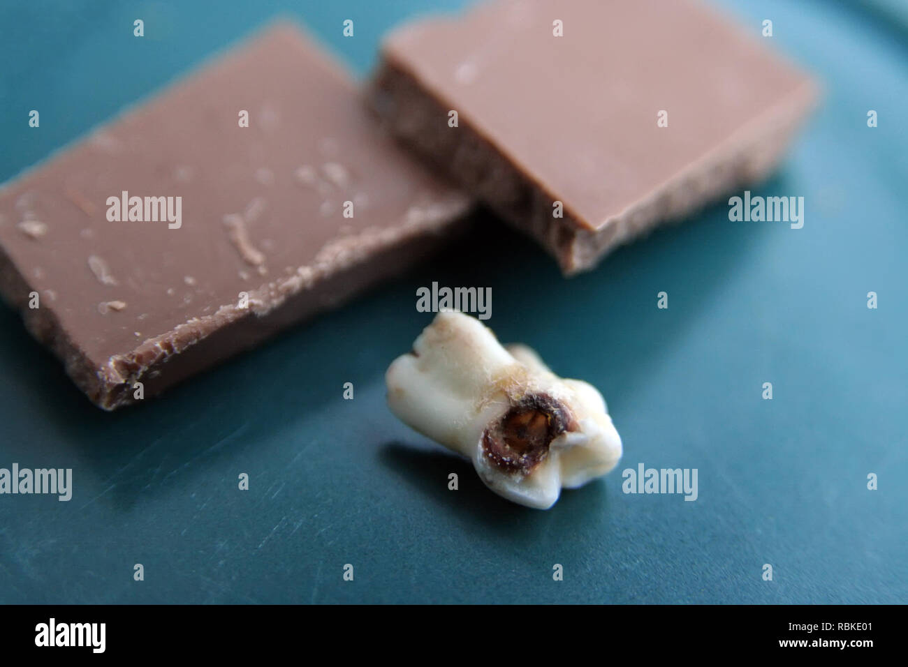 Bad tooth and piece of chocolate. Rotten tooth and chocolate. Unhealthy food. Importance of dental hygiene. Stock Photo